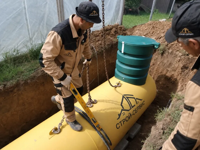 Монтажники у жёлтого газгольдера с высокой горловиной и стропами